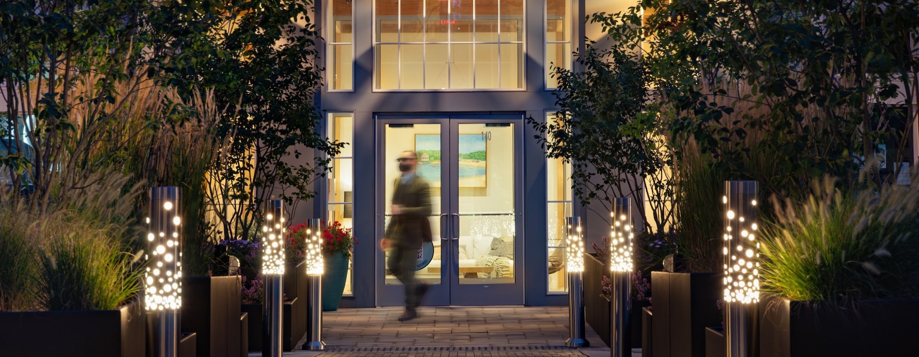 a person walks in front of an entrance to a building at night