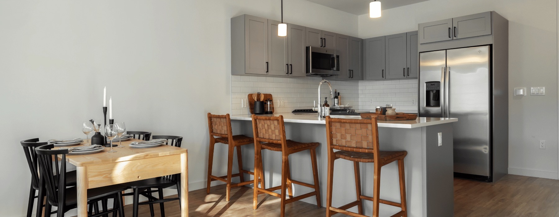 Model kitchen at our apartments in Darien, featuring wood grain floor paneling and stainless steel appliances.