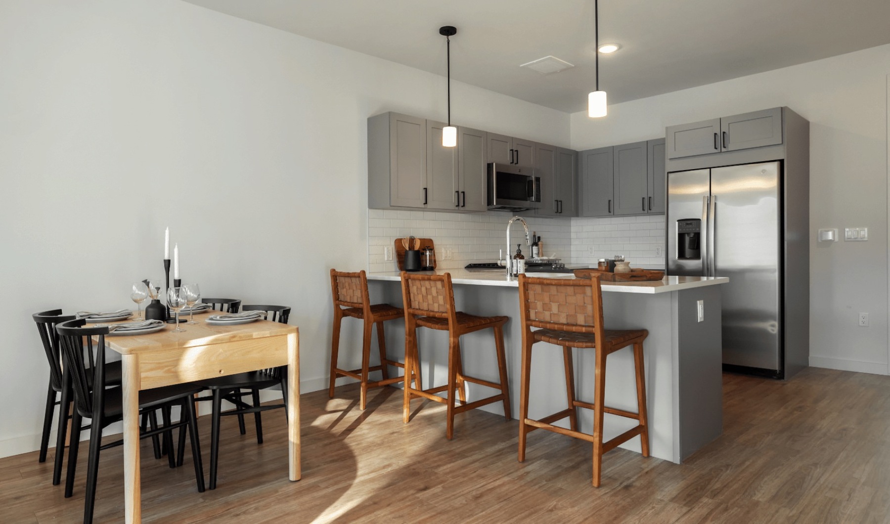 Model kitchen Model kitchen at our apartments for rent in Darien, CT, featuring wood grain floor paneling and counter seating.
