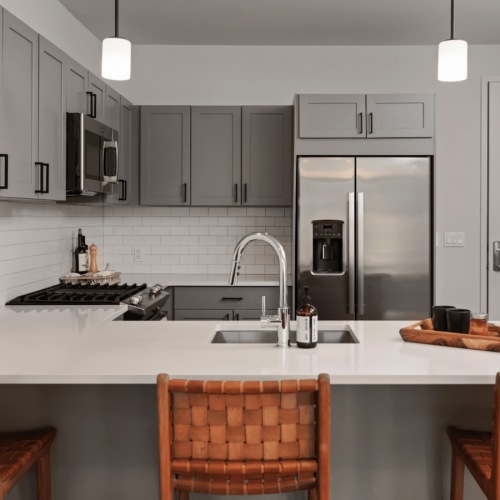 Model kitchen Model kitchen at our apartments for rent in Darien, CT, featuring wood grain floor paneling and counter seating.